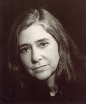 Margaret Hamilton with dark hair posing in front of a black background.