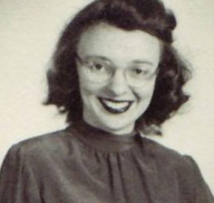 Marie Tharp wearing glasses smiling in front of a white background.