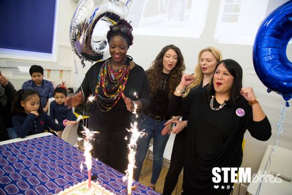 Team Stemette Members blowing out candles on a cake at the 5th Birthday party.