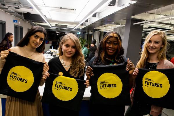 Four Stemettes holding Stemette Futures tote bags and smiling.