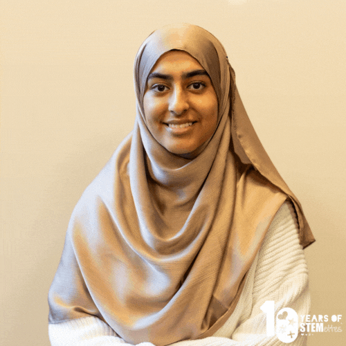 GIF of SFYB Aminah smiling and posing against a light wall