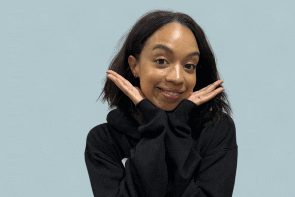 GIF of TeamStemette Charlotte smiling and posing against a light wall