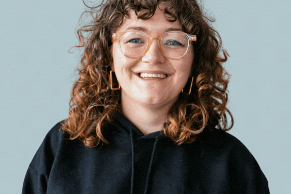 GIF of TeamStemette Hannah smiling and posing against a light wall