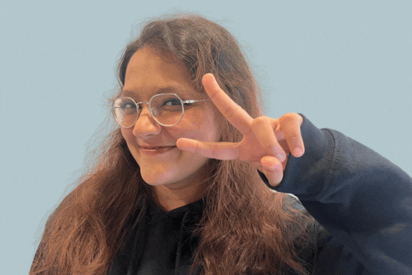GIF of TeamStemette Himani smiling and posing against a light wall
