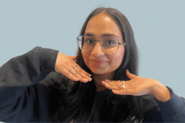 GIF of TeamStemette Sidra smiling and posing against a light wall