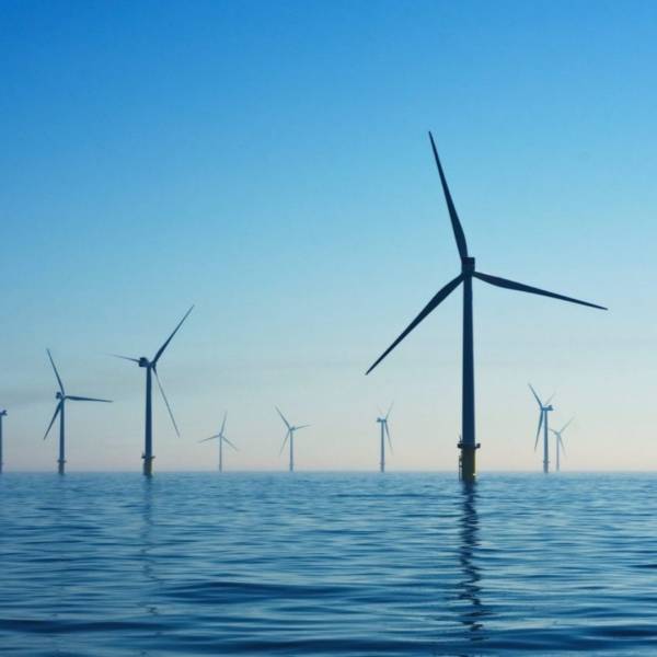 A wind farm in the sea, with wind turbines.