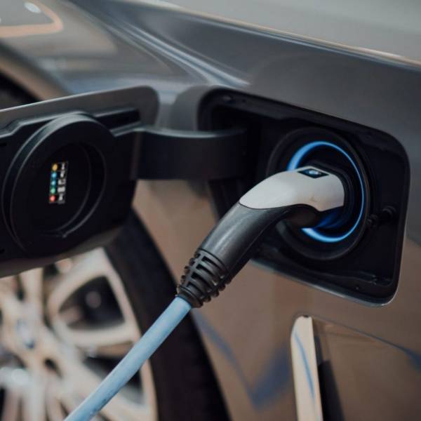 A charging cable plugged into the charging port of an electric car.